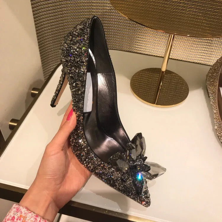 Gold women's high heel with pointed toe, rhinestones, and a stiletto heel on a white background.