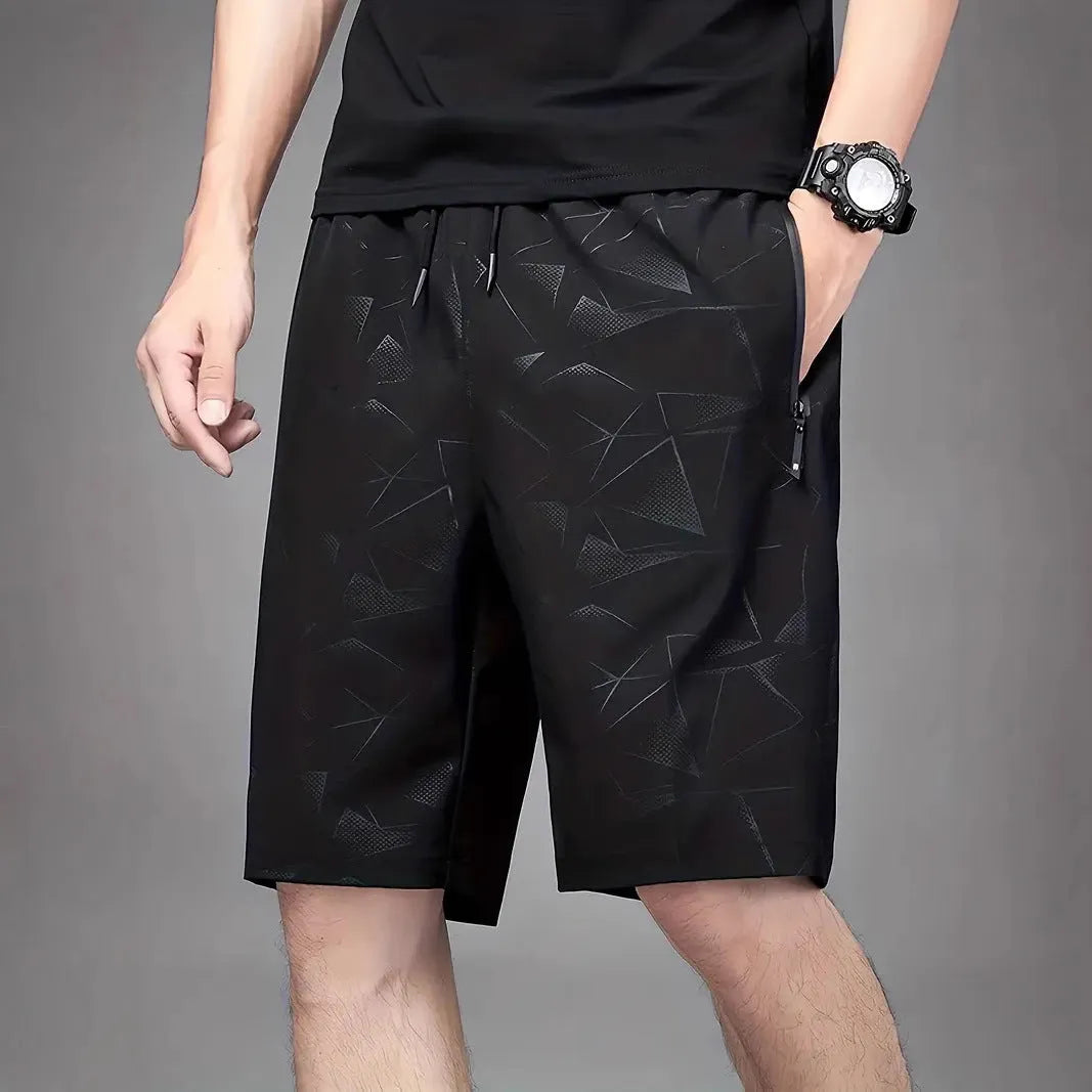 Men's loose grey polyester sports shorts with elastic waistband on a white background