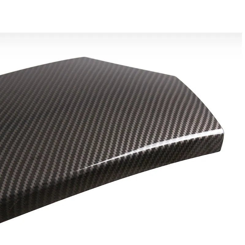 Three black ABS car armrest box covers with a shiny carbon fibre diagonal weave pattern.
