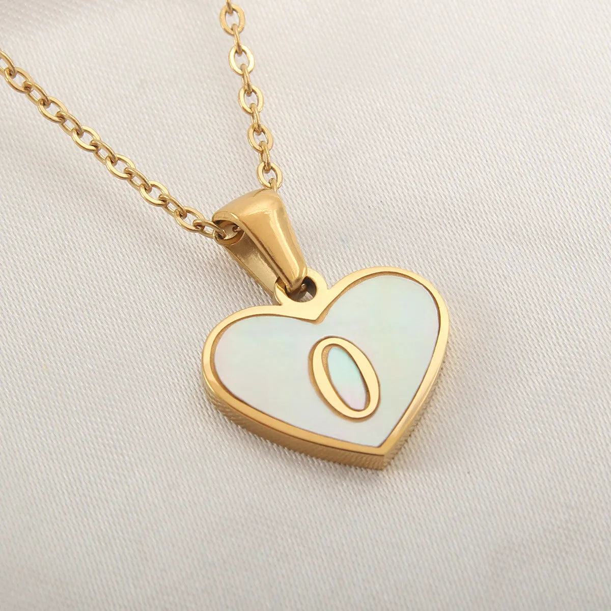 Gold heart necklace with white shell detail and personalised initial letter on adjustable chain