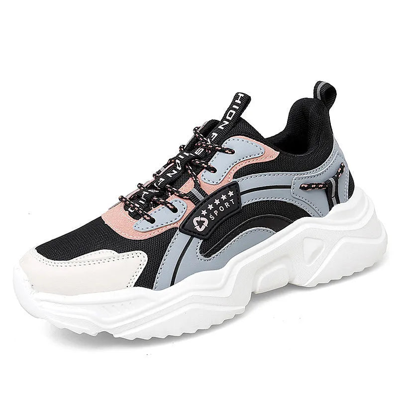 Women's white thick-soled casual sneakers with mesh upper and buckle detail on a light background.
