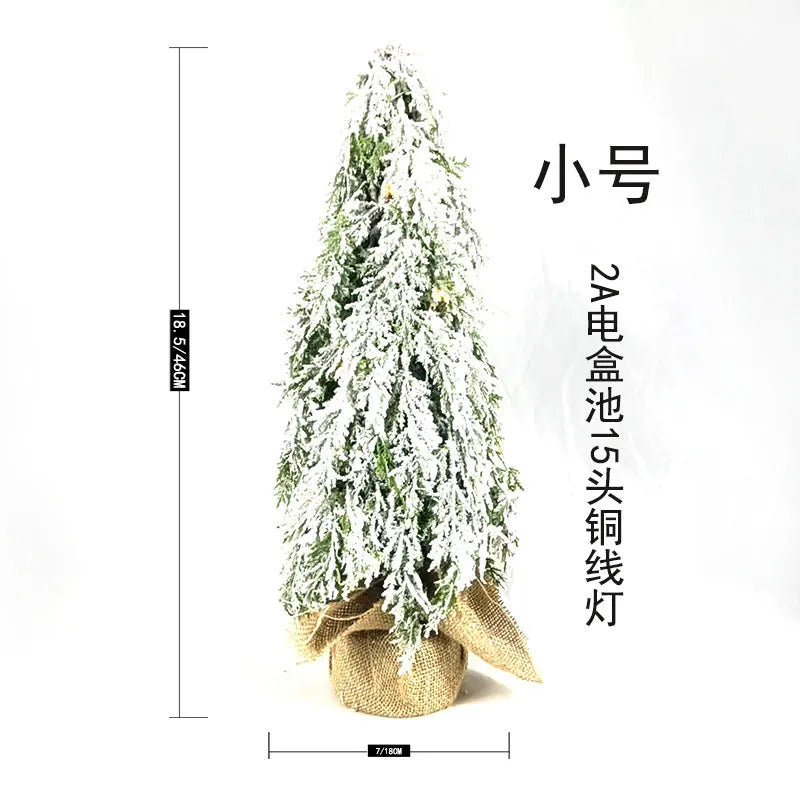 24 inch plastic Christmas tree with lights and PE snow decoration on desktop