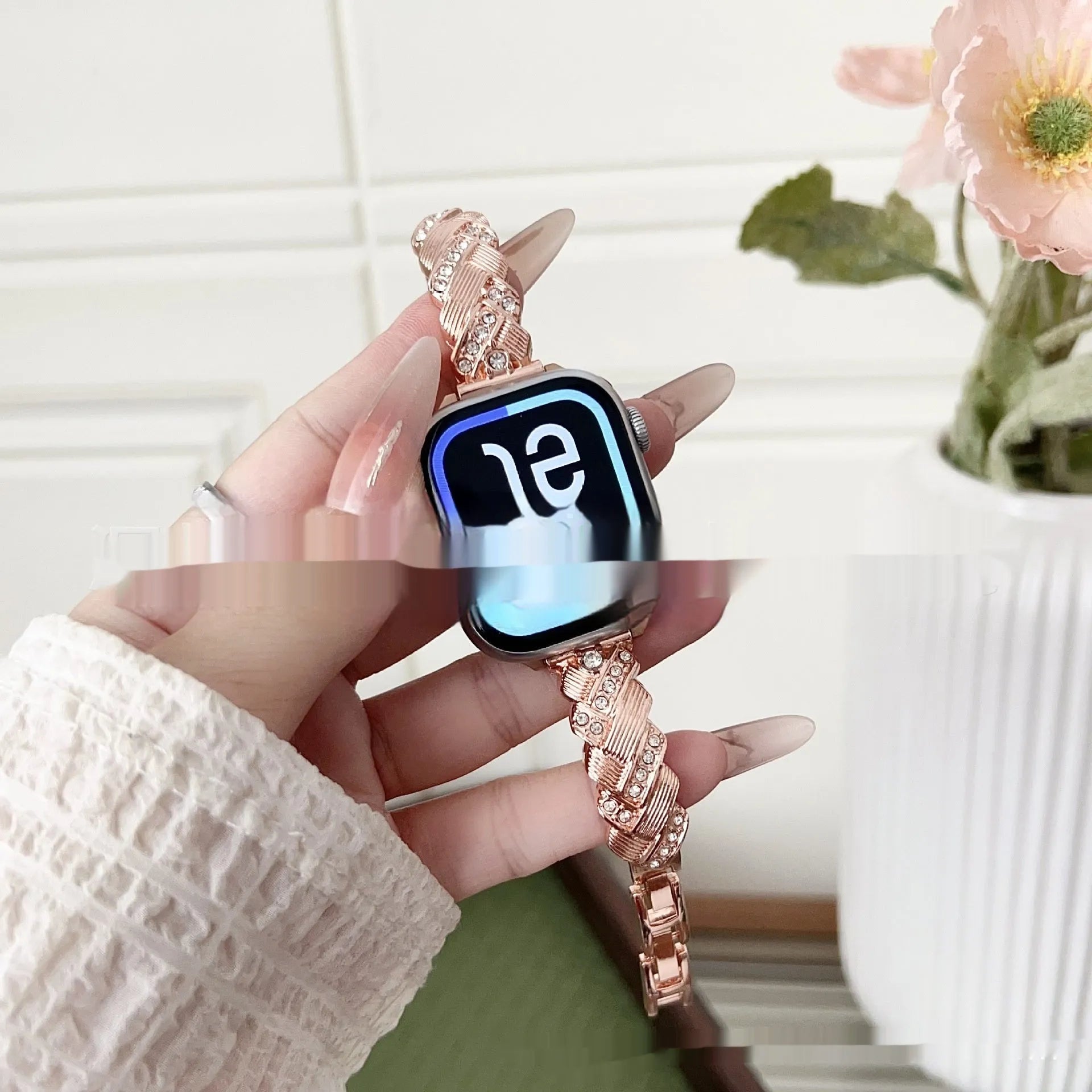 Zinc alloy watch strap with diamond twist design in rose gold colour, shown next to an Apple Watch.