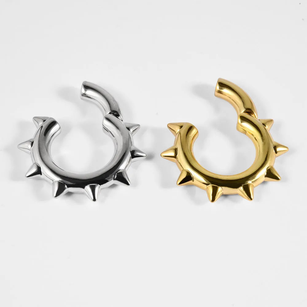 Solid copper magnetic ear expander earrings in a geometric sharp cone shape on a grey background.