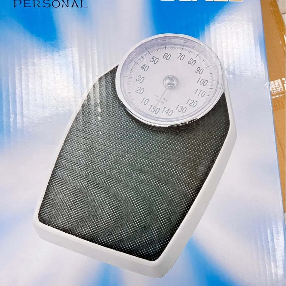 Black mechanical body weight scale with large dial and pointer on a simple platform.