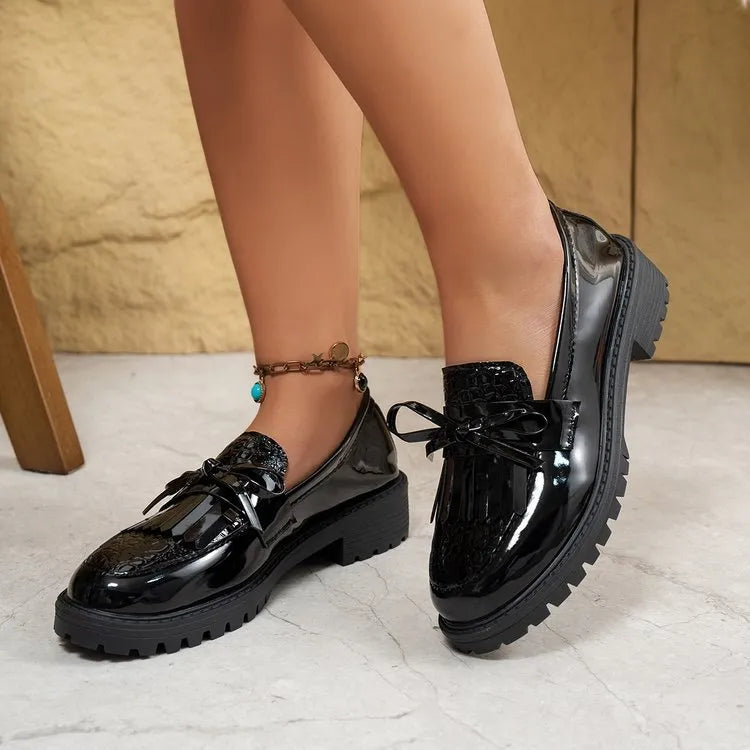 Women's brown and black loafers with bow detail on artificial PU upper, showing slip-on design