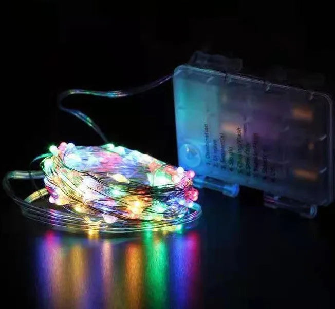 Copper wire battery-operated string lights wrapped around branch with multiple LED colours illuminated