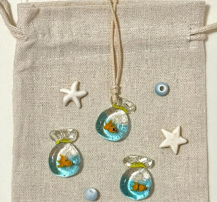 Women's necklace with coloured glaze joker charm on cotton linen chain in small fish lucky bag colour