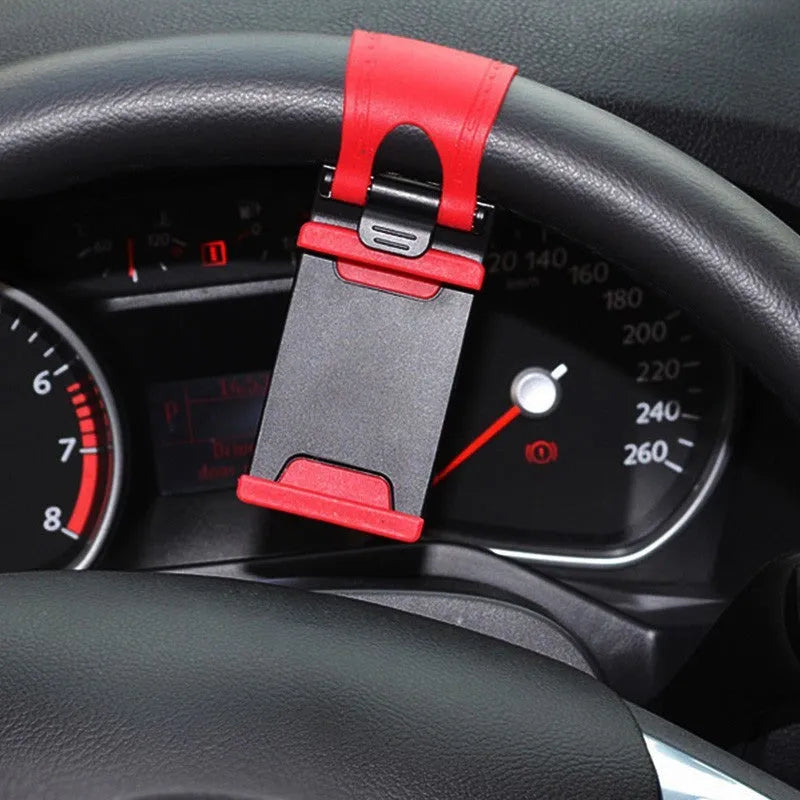 Universal black car steering wheel clip mount holder attached to a steering wheel, holding a mobile phone.