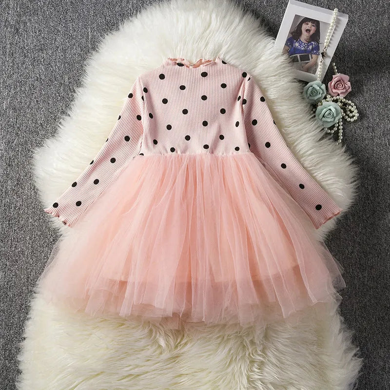Baby girl wearing a long sleeve lace and tutu dress in pink, suitable for a birthday party.