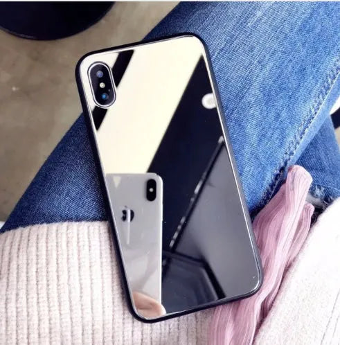 Black mirror iPhone back cover case for iPhone 7 Plus, 8 Plus, and X models on a table.