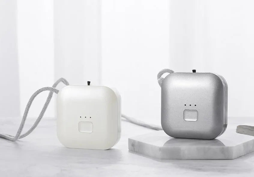 Mini USB portable air purifier necklace in pink, showing compact wearable design.