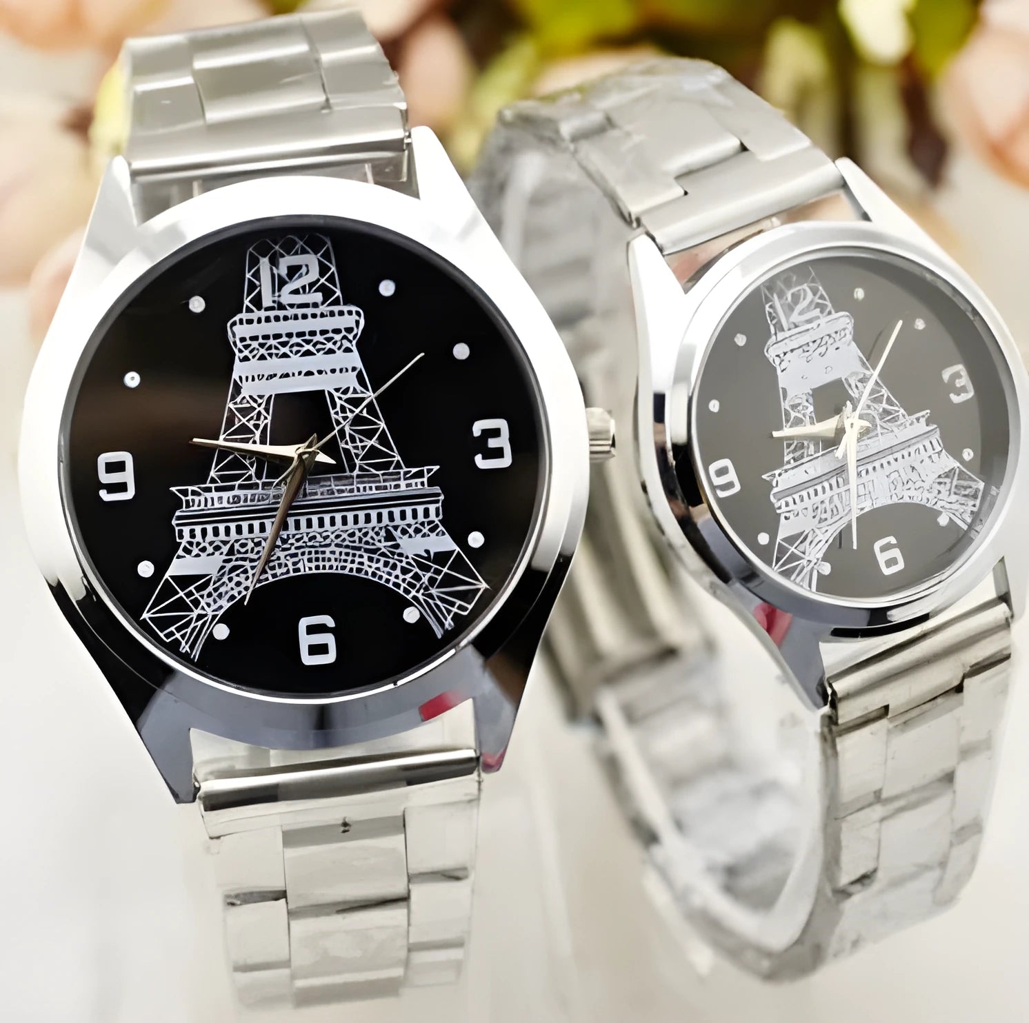Silver Eiffel Tower engraved dial on a stainless steel wrist watch with a silver-toned strap.