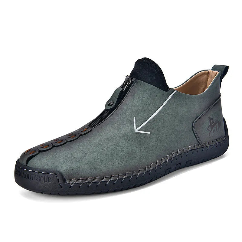 Men's brown leather boots with front zip closure and hand-stitched rubber soles