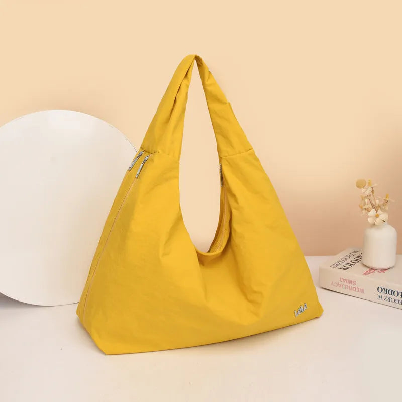 Soft nylon women's underarm bag in a heart shape, shown in black, blue, khaki, and yellow colours.