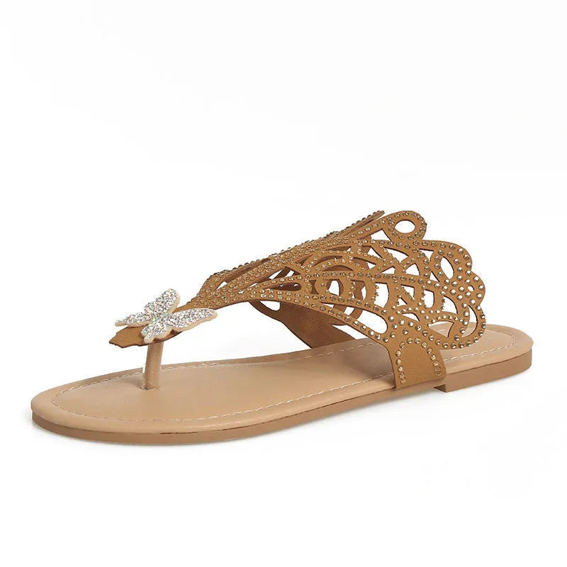 Women's black slip-on sandals with rhinestone decorations and a flat rubber sole.