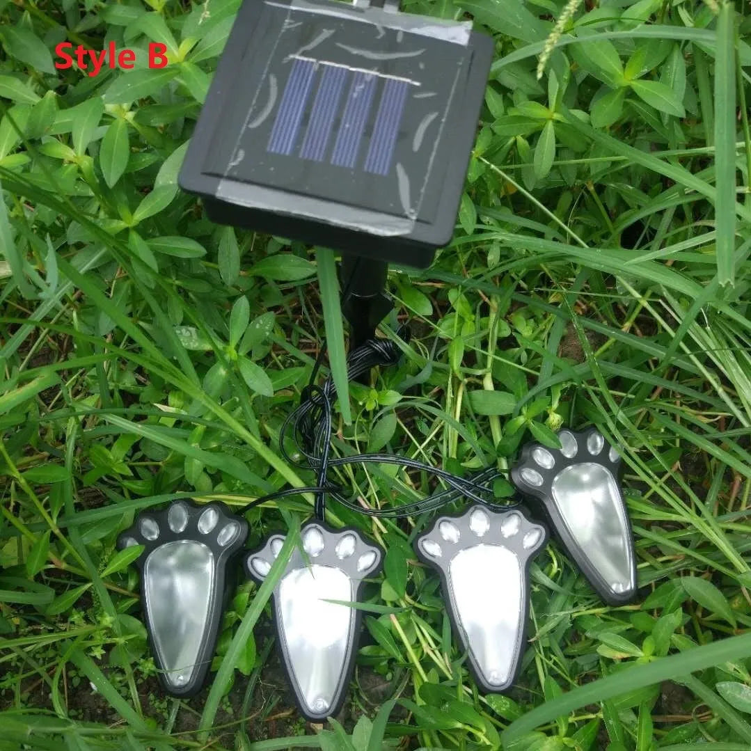 Black bear paw shaped solar garden lights with four paw prints connected to solar panel