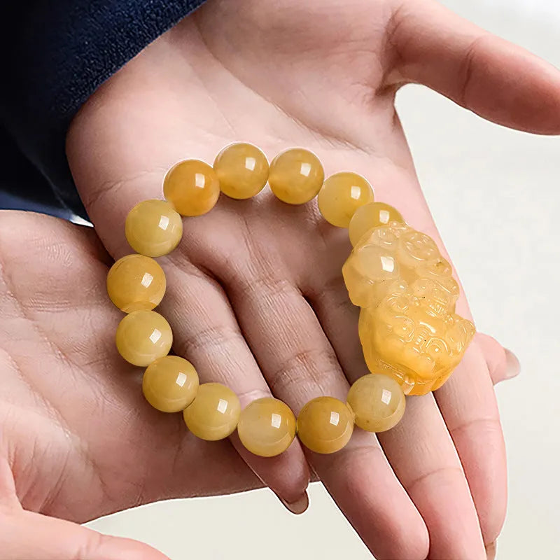 Carved Golden Thread Jinsi Jade bracelet with money motif on adjustable cord, shown in two bead sizes.