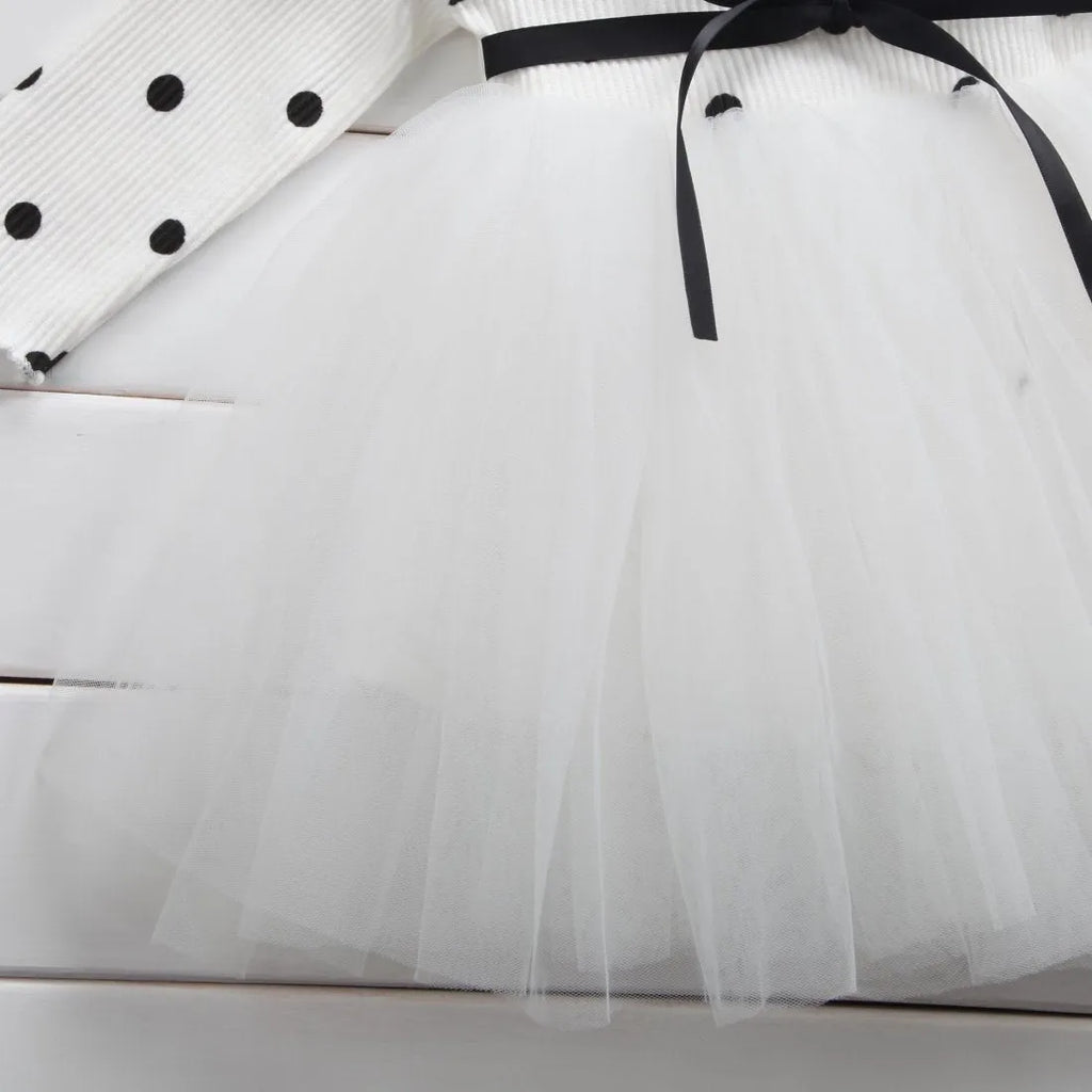 Baby girl wearing a long sleeve lace and tutu dress in pink, suitable for a birthday party.