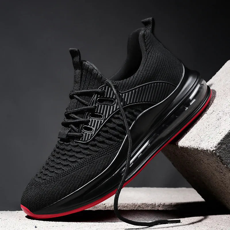 Men's black low-top running shoes with mesh upper and white rubber sole on a plain background.
