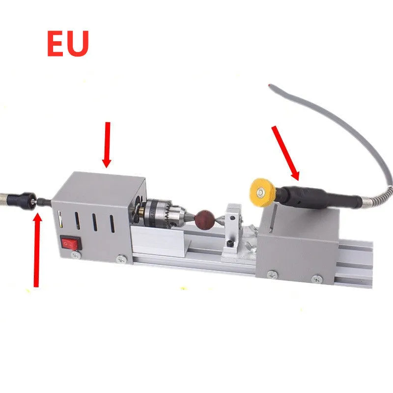 Silver metal mini woodworking lathe on a bench with carving knives and accessories.