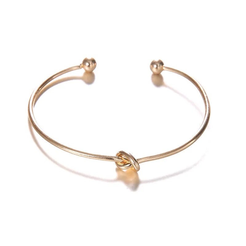 Women's vintage gold arrow knotted cuff bracelet made from electroplated alloy.