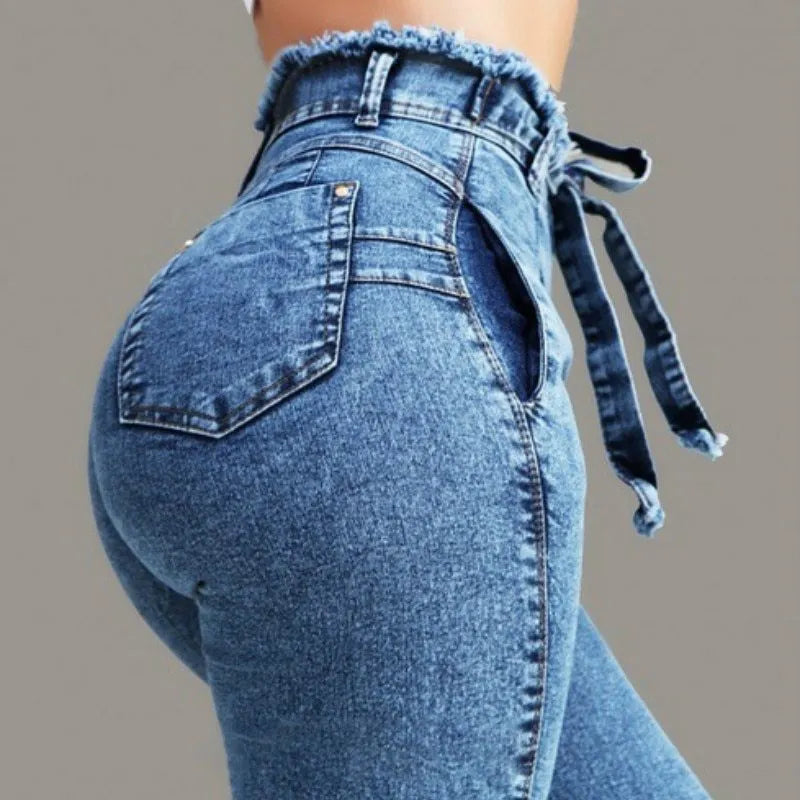 Women's fringed jeans in cowboy denim fabric showing decorative leg fringing detail