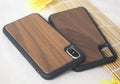 Wooden iPhone case with carbonised bamboo back and black TPU sides on a wooden table.