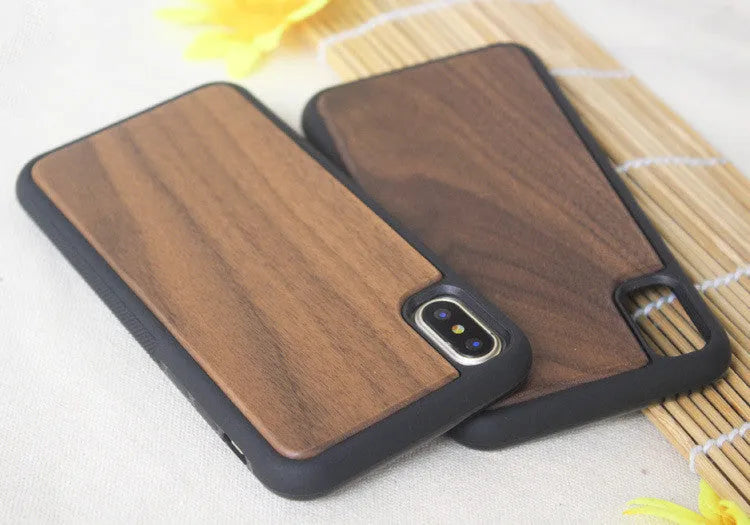 Wooden iPhone case with carbonised bamboo back and black TPU sides on a wooden table.