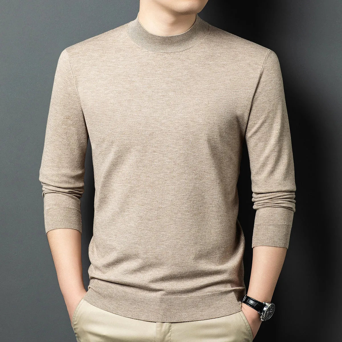 Man wearing a round neck long sleeve wool blend pullover sweater in a neutral colour.