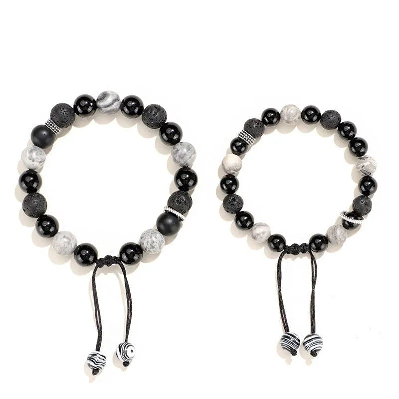 Black agate map stone and volcanic rock bracelet in diamond shape on a wrist.