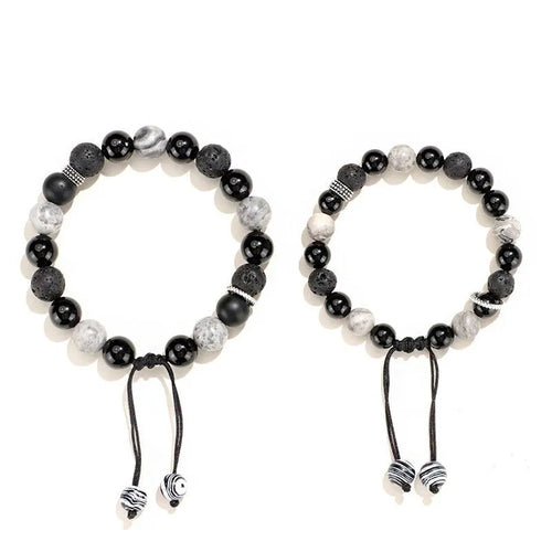 Black agate map stone and volcanic rock bracelet in diamond shape on a wrist.