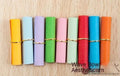 Assortment of colourful mini paper scrolls with metal eyelets in various sizes.