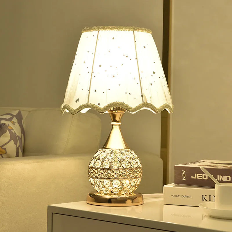 Gold crystal desk lamp with iron art base on a wooden table