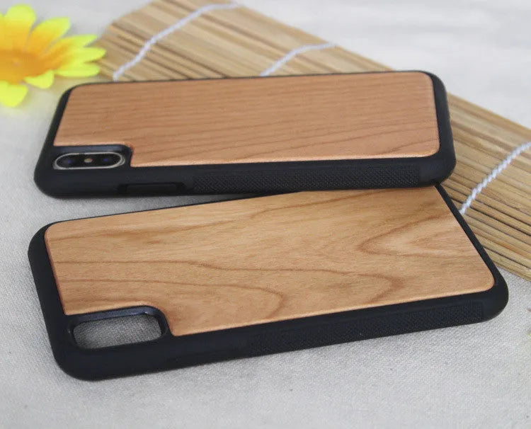 Wooden iPhone case with carbonised bamboo back and black TPU sides on a wooden table.