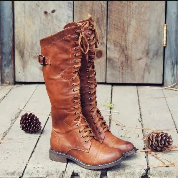 Women's black chunky heel high leg boots with a round toe on a plain background.