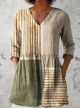 A woman modelling a printed, loose-fitting dress with a wide waist and three-quarter length sleeves.