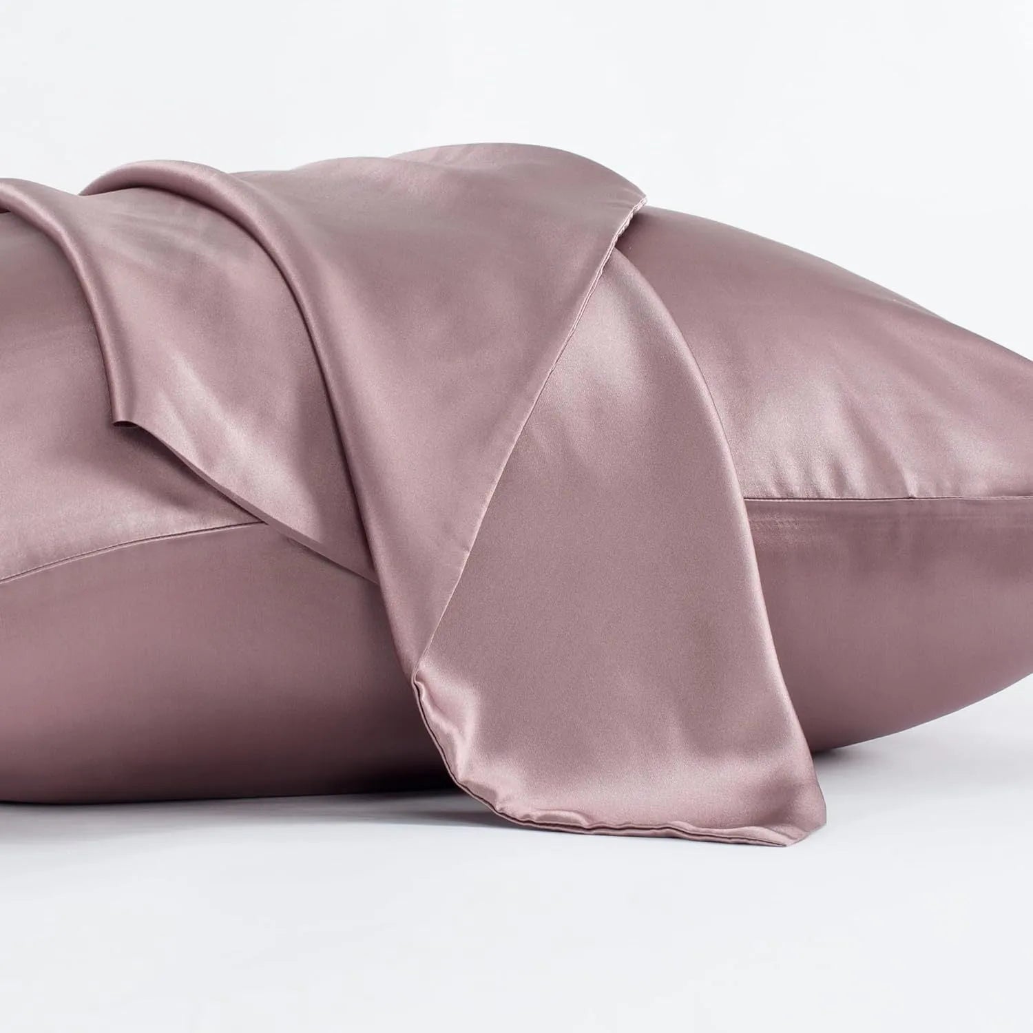 Dark grey envelope closure silk pillowcase on a bed.