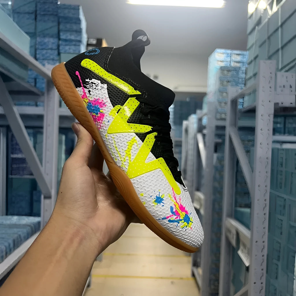 Low-cut black and yellow football boots with replaceable screw-in studs on rubber sole.