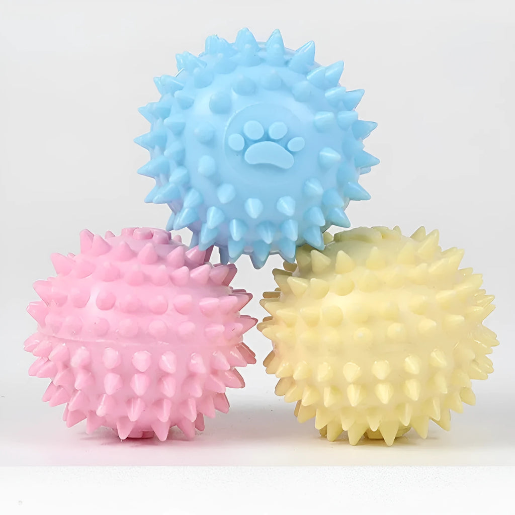 Blue, pink, or yellow TPR dog chewing ball with textured sides for tooth cleaning
