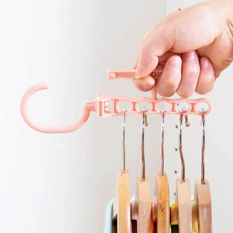Blue revolving wardrobe hanger with five branches and a central handle for organising clothes.
