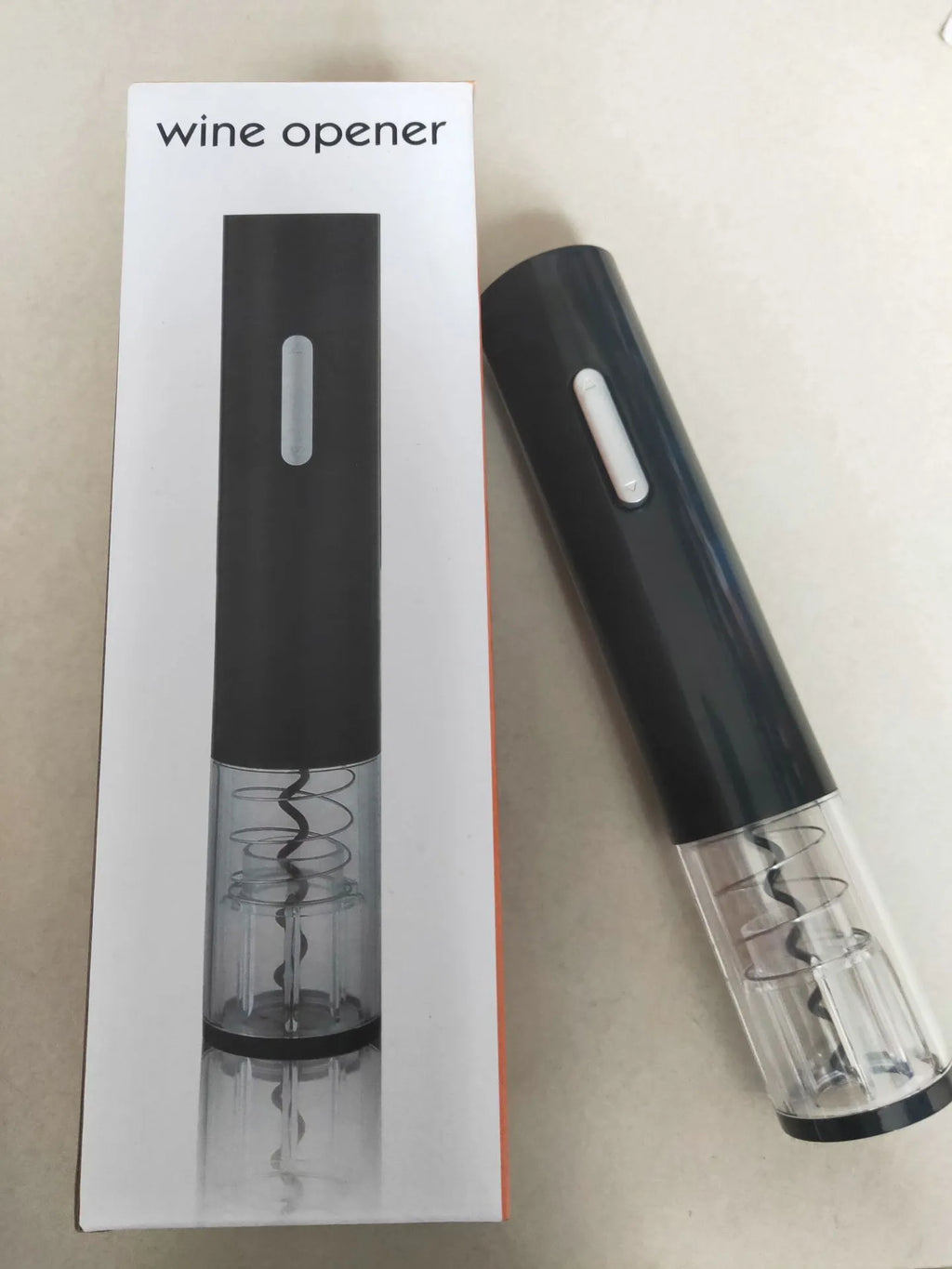 Black automatic electric wine bottle opener with foil cutter on a wooden table