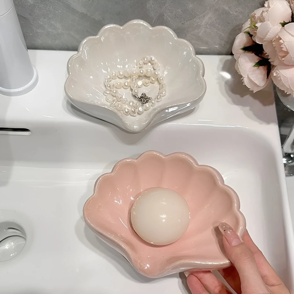 White shell-shaped plastic soap dish on a bathroom counter.