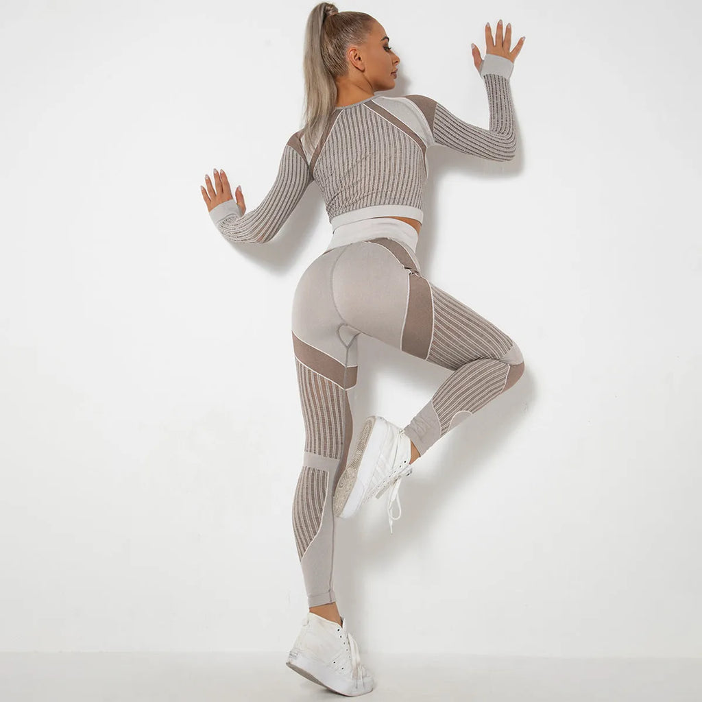 Women's black seamless knitted long-sleeved yoga wearsuit with stripe pattern, shown in a yoga pose.