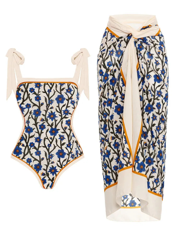 Women's floral print two-piece swimsuit with a blue chiffon skirt laid flat.