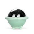 UFO-shaped plastic starry sky projection night light in pink on a wooden surface