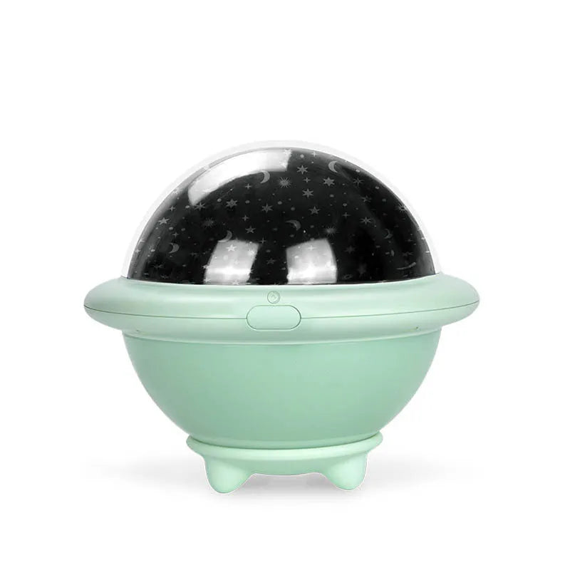 UFO-shaped plastic starry sky projection night light in pink on a wooden surface