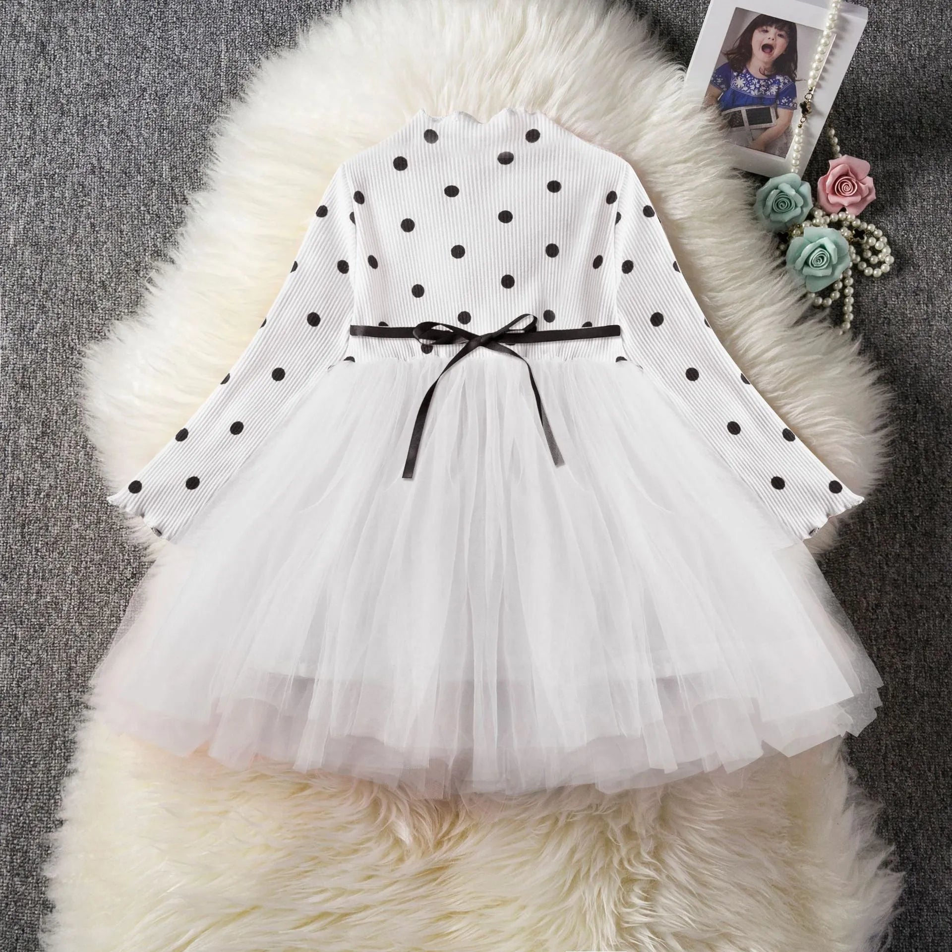 Baby girl wearing a long sleeve lace and tutu dress in pink, suitable for a birthday party.