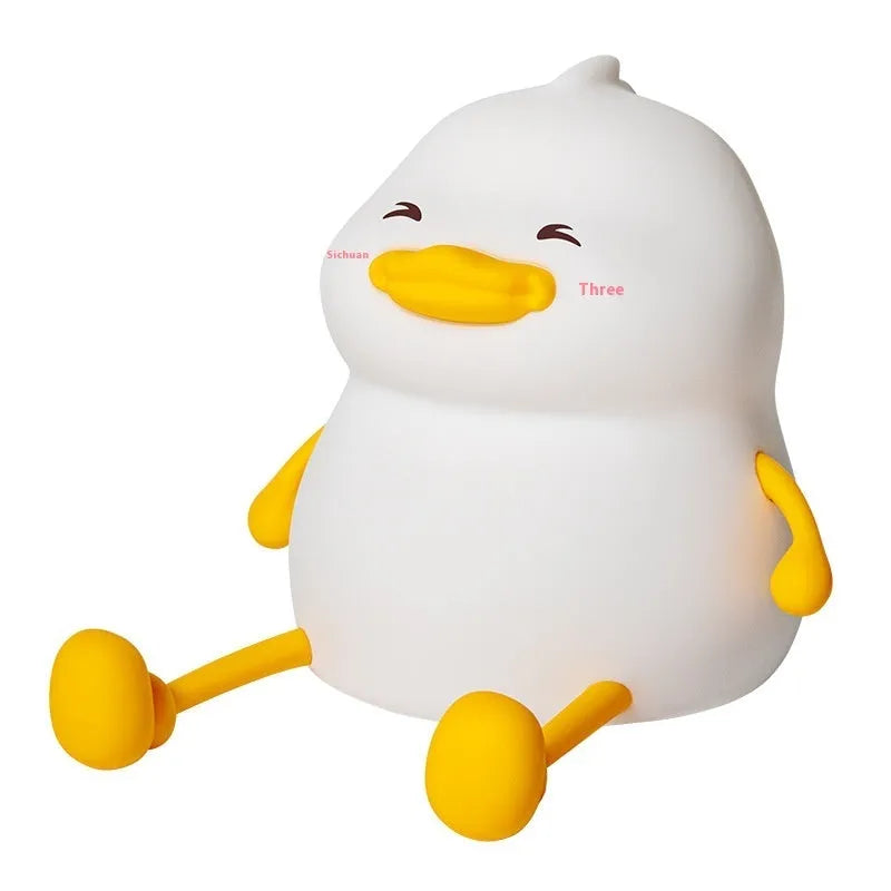 Chubby rechargeable silicone pat night lamp on desk holding a mobile phone