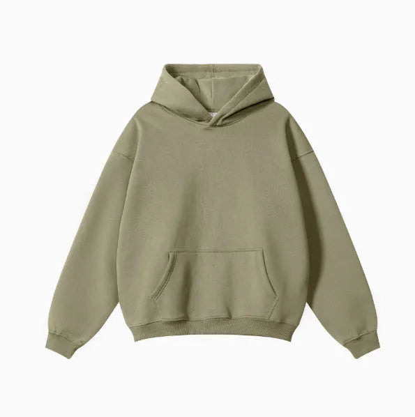 Man wearing a loose-fit grey cotton terry hooded sweater with drop-shoulder sleeves.